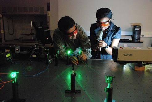 Two students working with a laser