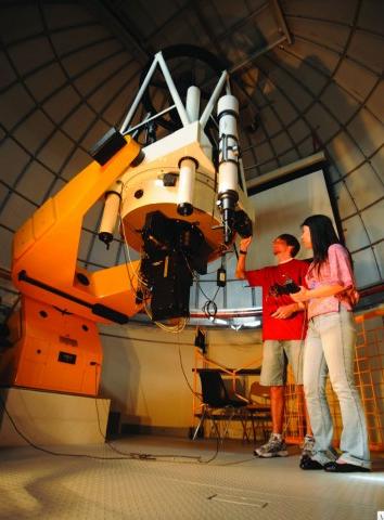 Two students looking through a telescope