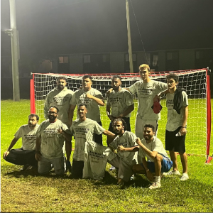 Students from the champion intramural soccer team smiling and posing in front of a goal.